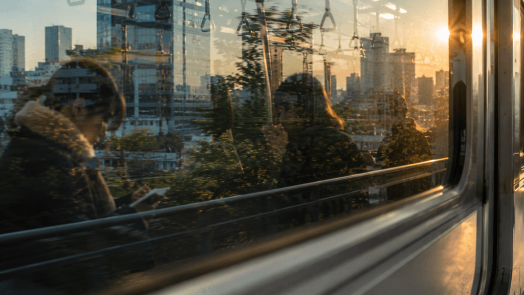 City reflections through a train window during the morning commute