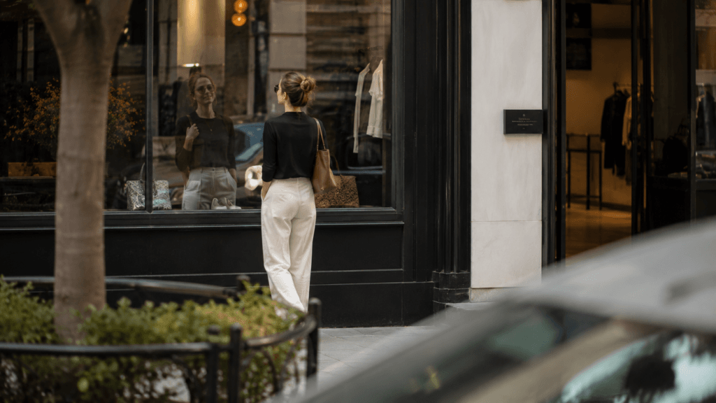 Woman checking her reflection in a boutique window
